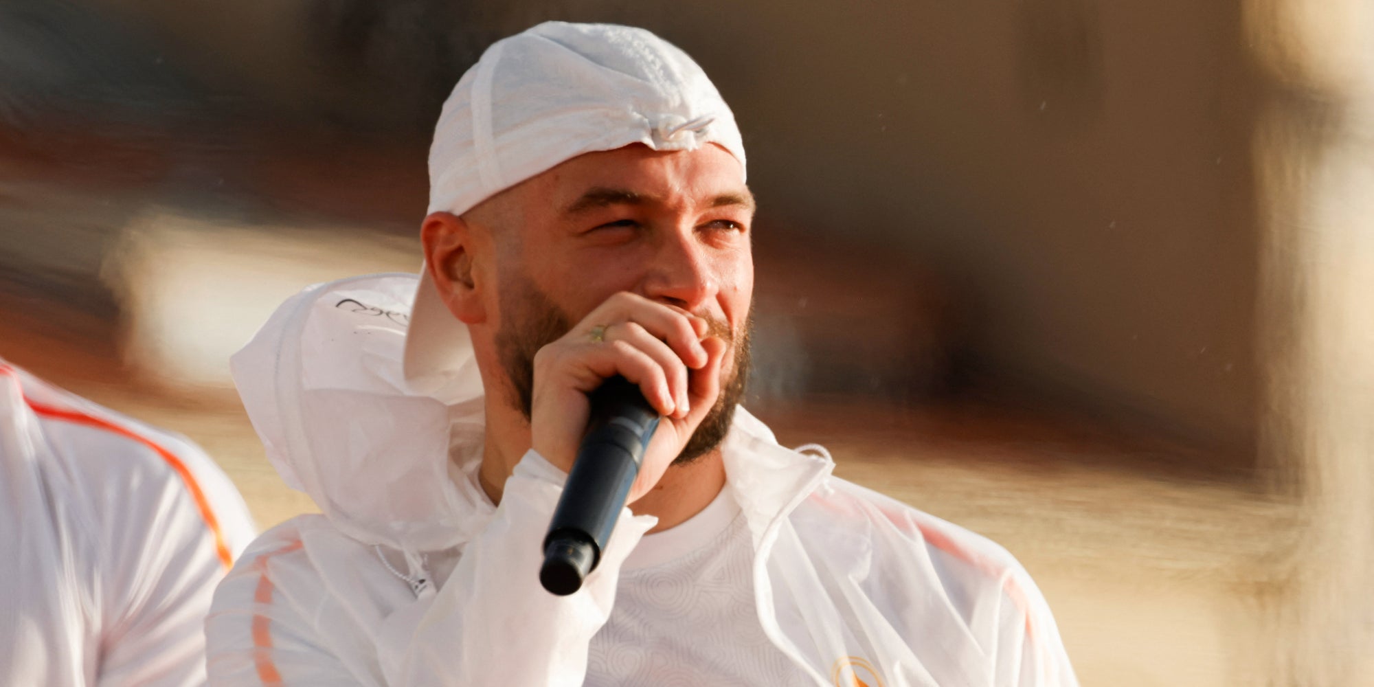 Le rappeur marseillais JUL, de son vrai nom Julien Mari, donnant un discours lors de la cérémonie d'arrivée de la Flamme Olympique au Vieux-Port de Marseille, le 8 mai 2024.