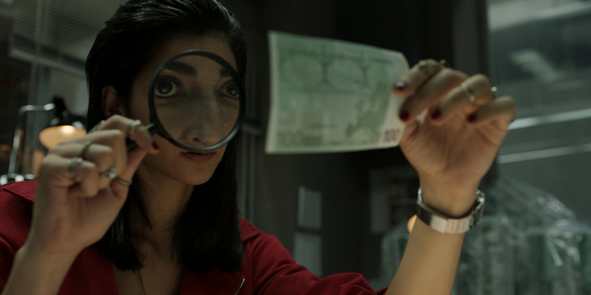 Nairobi, membre iconique des braqueurs de La Casa de Papel, en pleine examen d'un billet de banque.