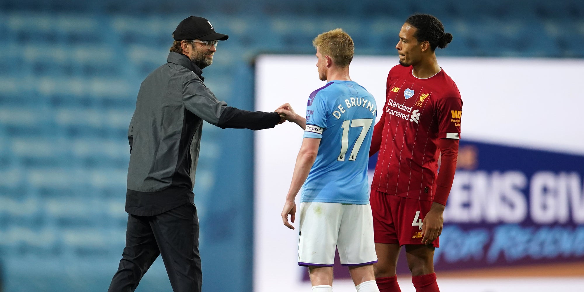 Klopp, l'entraîneur de Liverpool, son défenseur Van Dijk et De Bruyne de Manchester City, le 2 juillet 2020 à Manchester