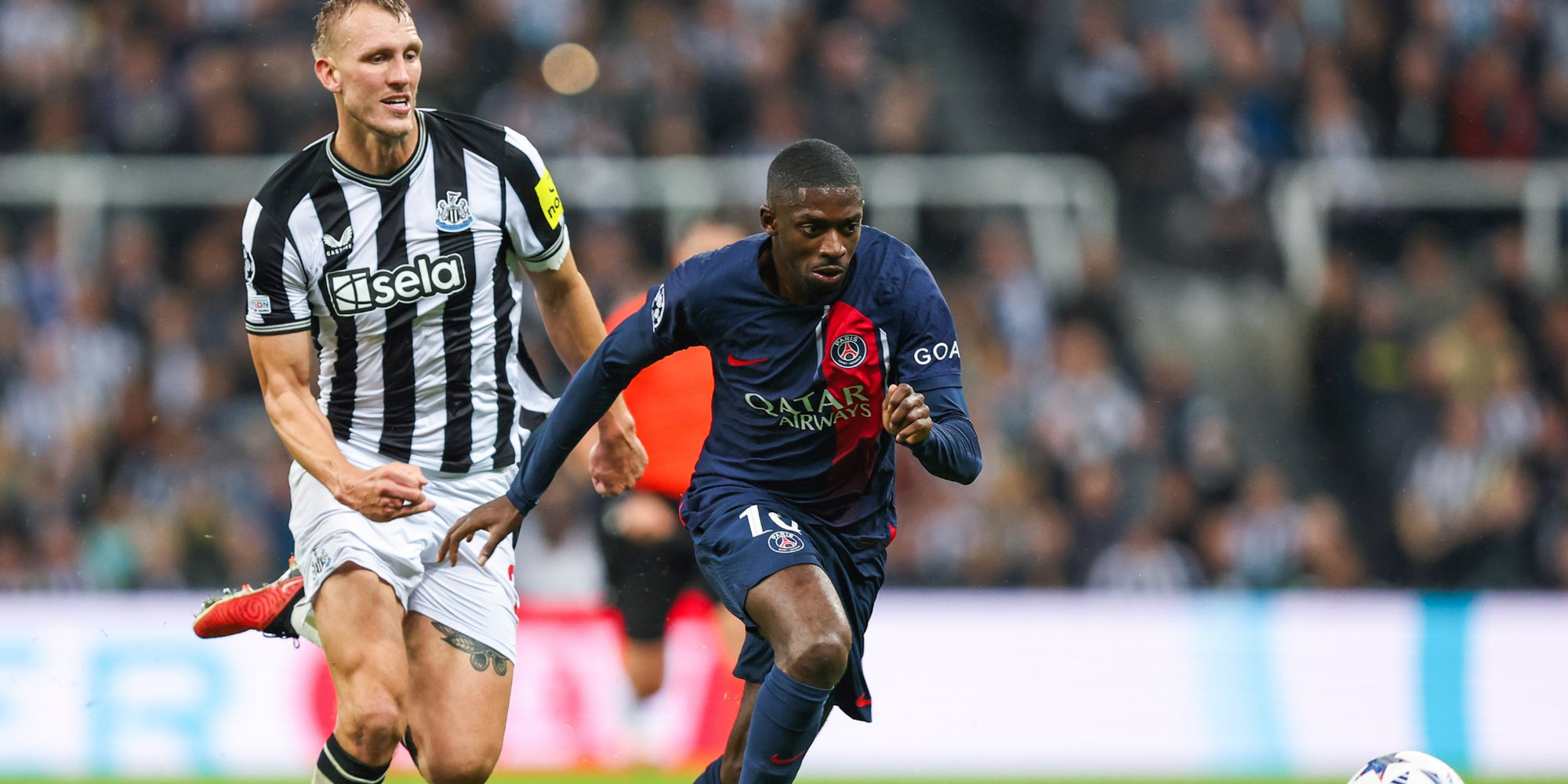 Dan Burn (Newcastle) et Ousmane Dembélé (PSG) lors du choc entre Newcastle et le Paris Saint-Germain en Ligue des Champions, le 4 octobre 2023 au St James' Park. 