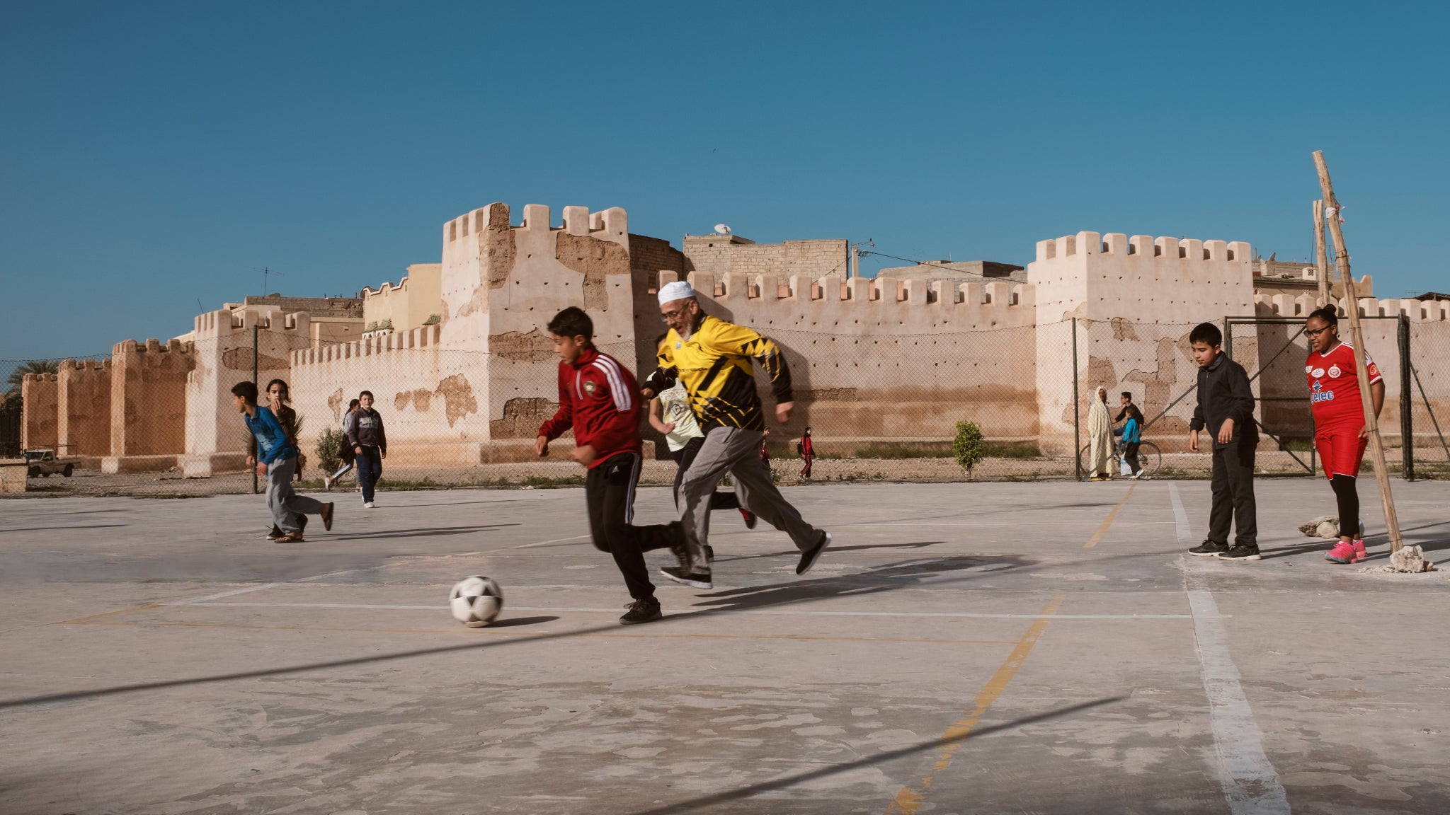 Trois enfants jouant au football dans les rues de Chefchaouen, au Maroc. Une photo présente dans l’exposition “Foot et Monde Arabe, la révolution du ballon rond”, à l’Institut du Monde Arabe.