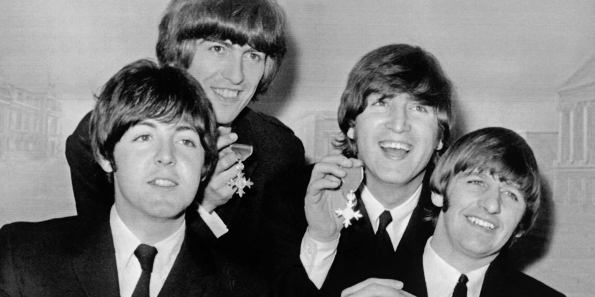 Les Beatles brandissent leur Bristish Empire Medal lors de la conférence de presse qui a suivi leur investiture le 26 octobre 1965 au Palais de Buckingham à Londres.