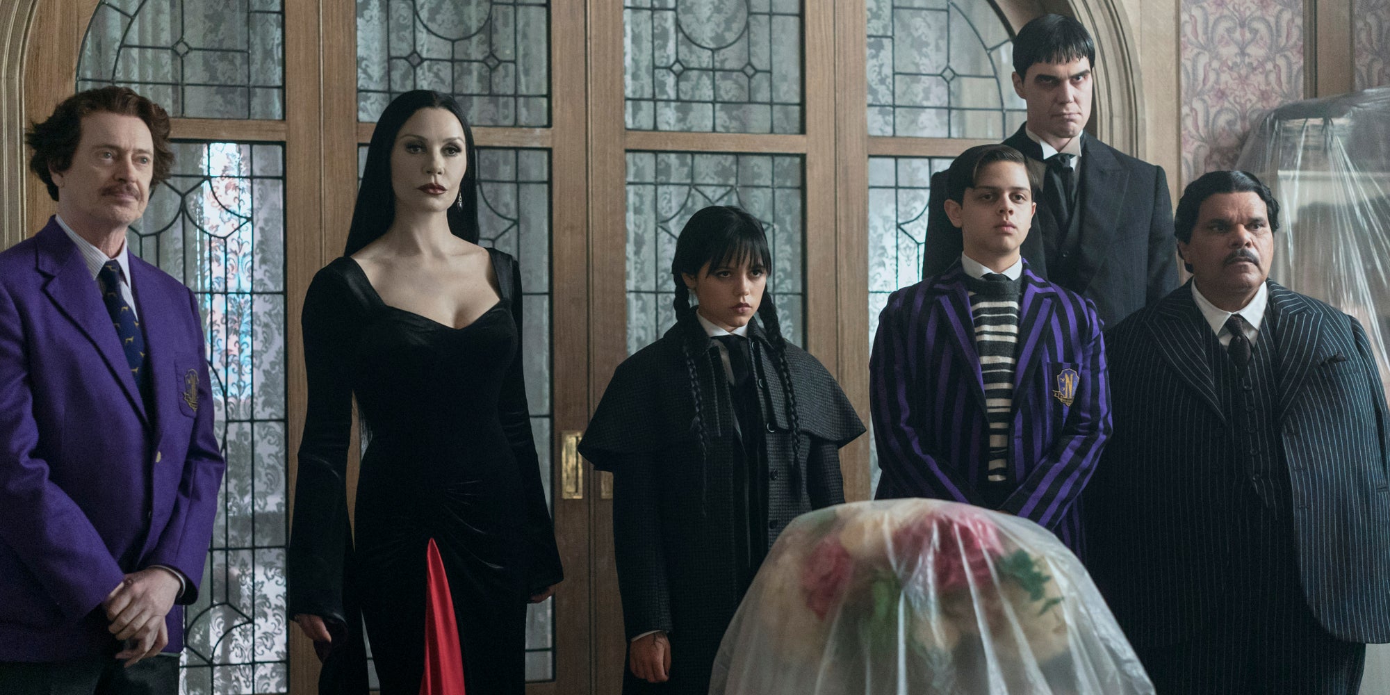 Steve Buscemi (Barry Dort), Catherine Zeta-Jones (Morticia Addams), Jenna Ortega (Mercredi Addams), Isaac Ordonez (Pugsley Addams), Joonas Suotamo (Lurch) et Luis Guzmán (Gomez Addams) dans l'épisode 1 de Mercredi.