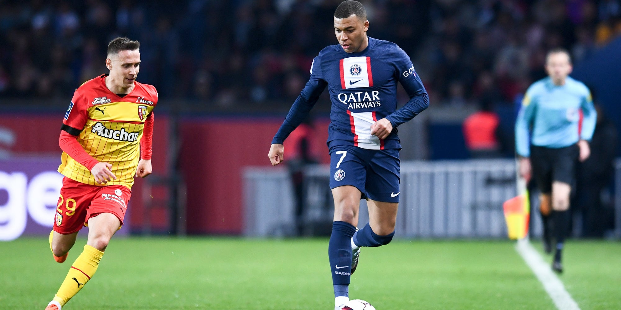Przemyslaw Frankowski (RC Lens) et Kylian Mbappé (PSG) lors du match de Ligue 1 2022-23 entre Paris et Lens, le 15 avril 2023 au Parc des Princes. 