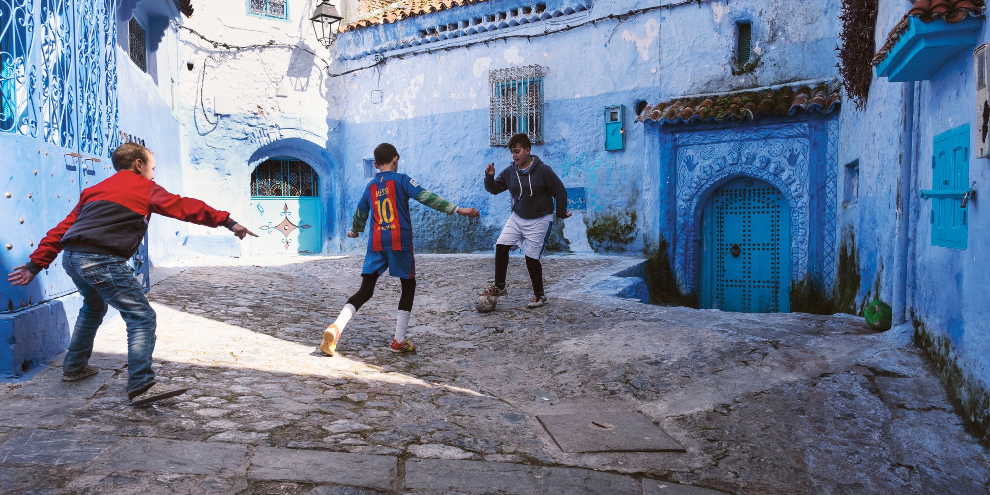 Un grand-père jouant au football avec des enfants à Taroudant, au Maroc. Une photo présente dans l’exposition “Foot et Monde Arabe, la révolution du ballon rond”, à l’Institut du Monde Arabe.