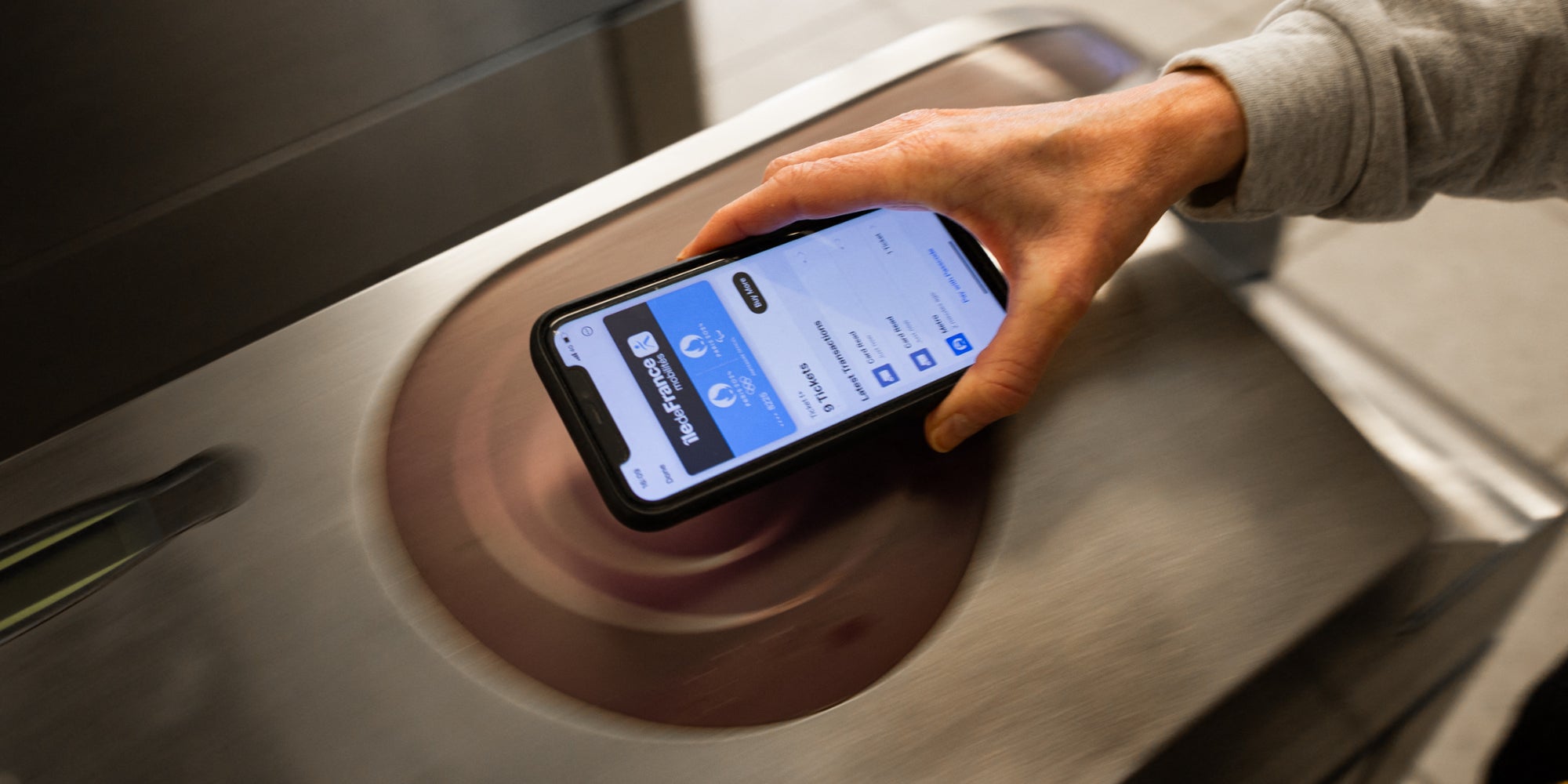 Un passager équipé d’un iPhone validant son ticket de métro, le 24 mai 2024 dans une station parisienne.