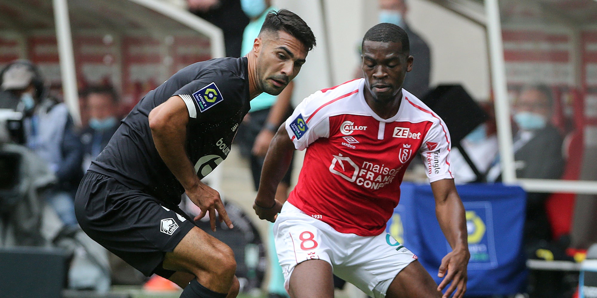 Kutesa (en rouge) à la lutte avec Celik lors du match de Ligue 1 Reims-Lille, le 30 août 2020 au stade Auguste Delaune, Reims