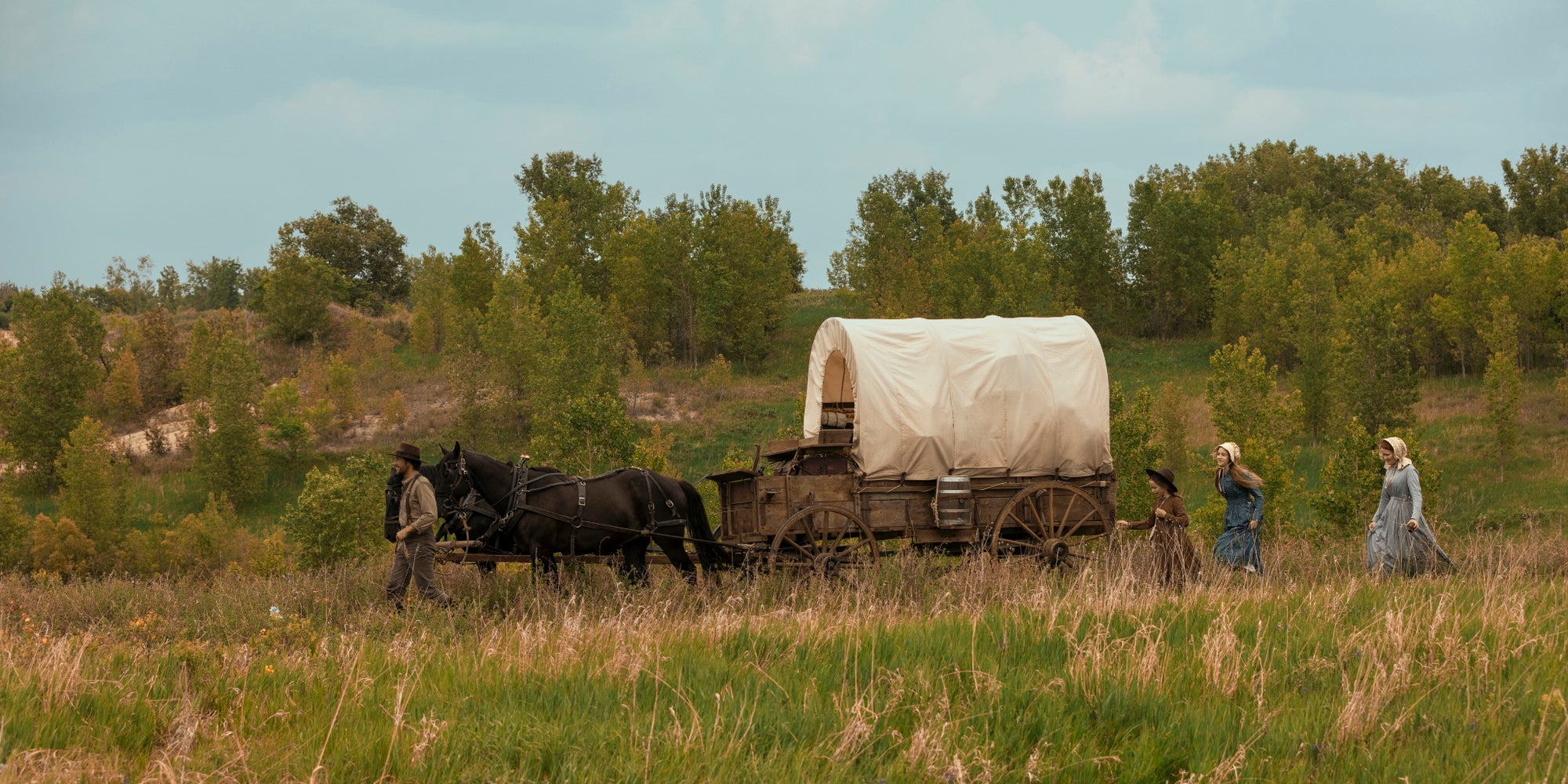 Luke Bracey (Charles Ingalls), Alice Halsey (Laura Ingalls), Skywalker Hughes (Mary Ingalls) et Crosby Fitzgerald (Caroline Ingalls) dans le premier épisode de La Petite Maison dans la prairie sur Netflix. 
