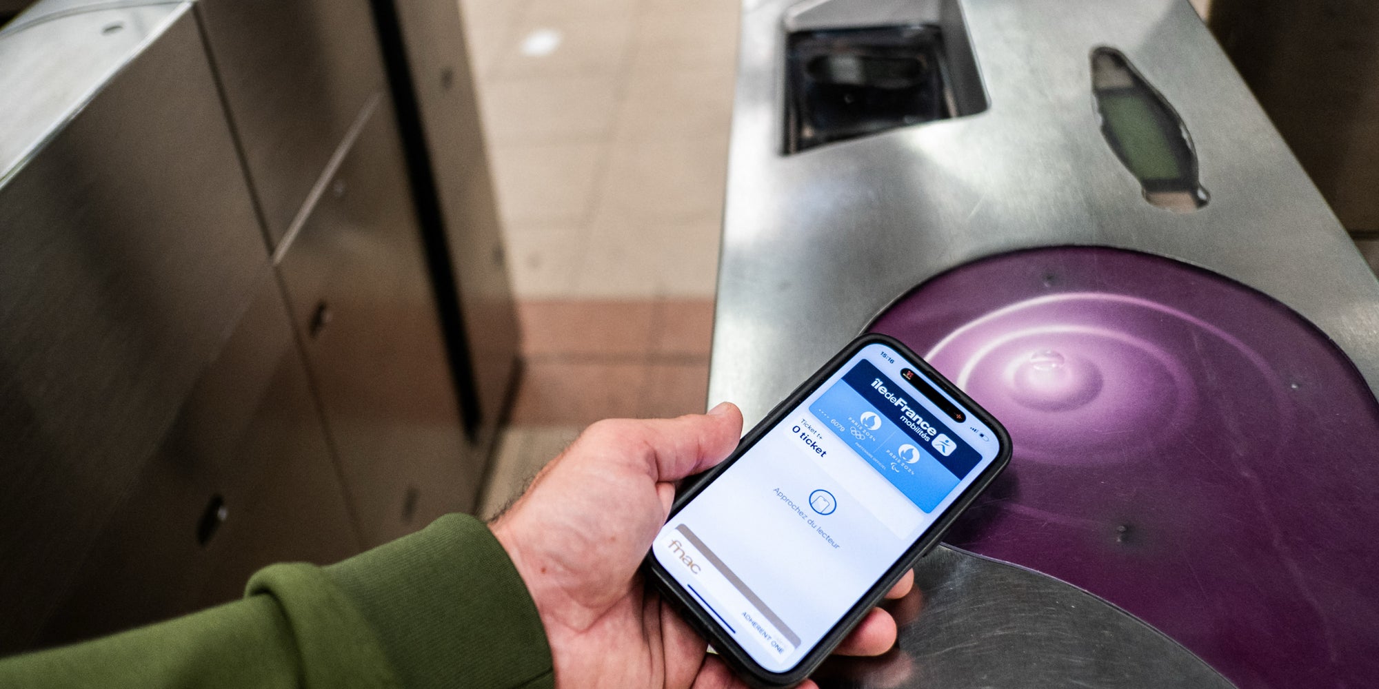 Un passager utilisant son smartphone pour prendre les transports en commun parisiens, à Gare de Lyon, le 20 juin 2024. 
