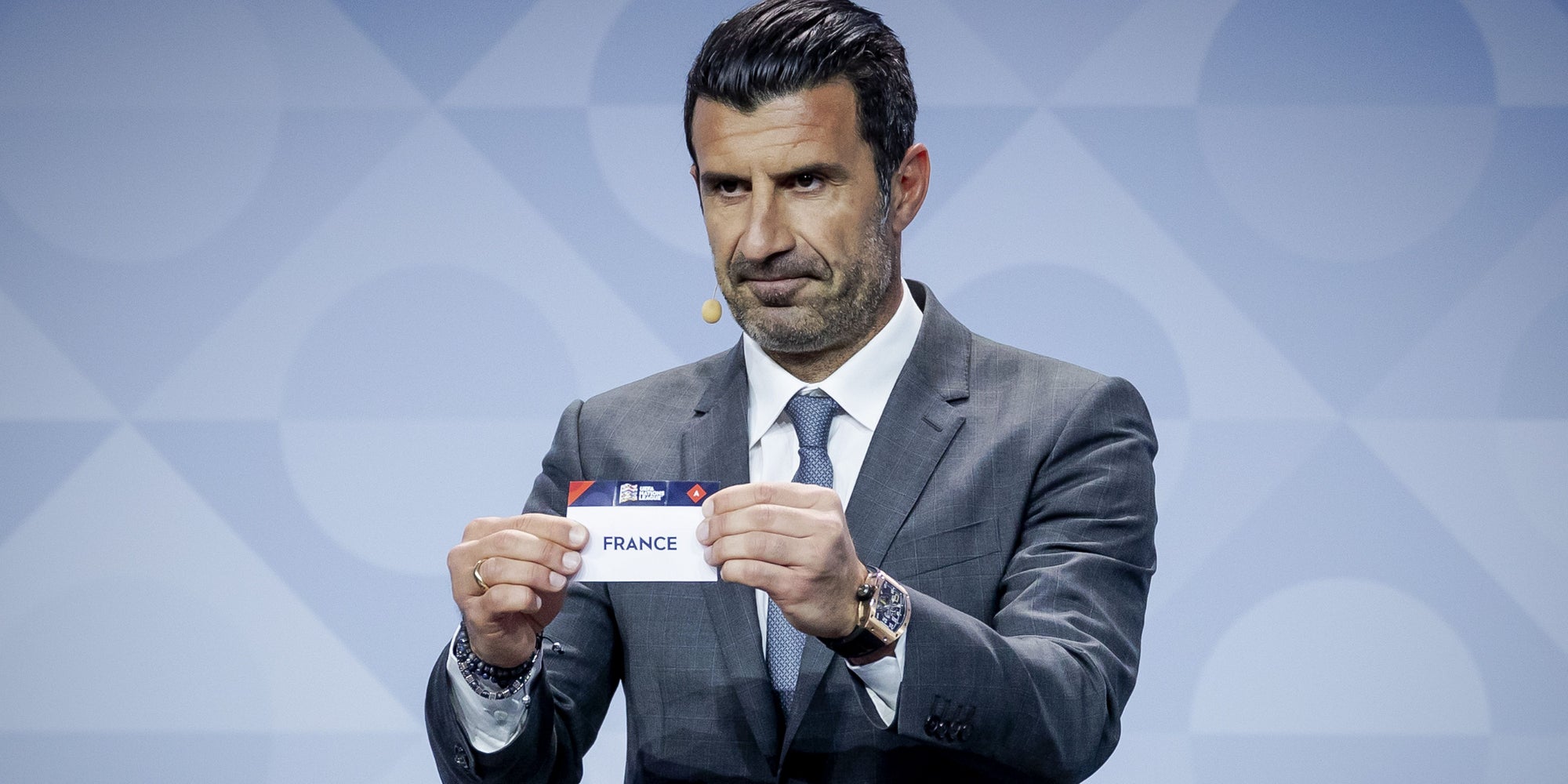 L'ancien footballeur portugais Luis Figo pioche le ticket de la France pendant le tirage au sort pour la Ligue des Nations, à Amsterdam, le 3 mars 2020.