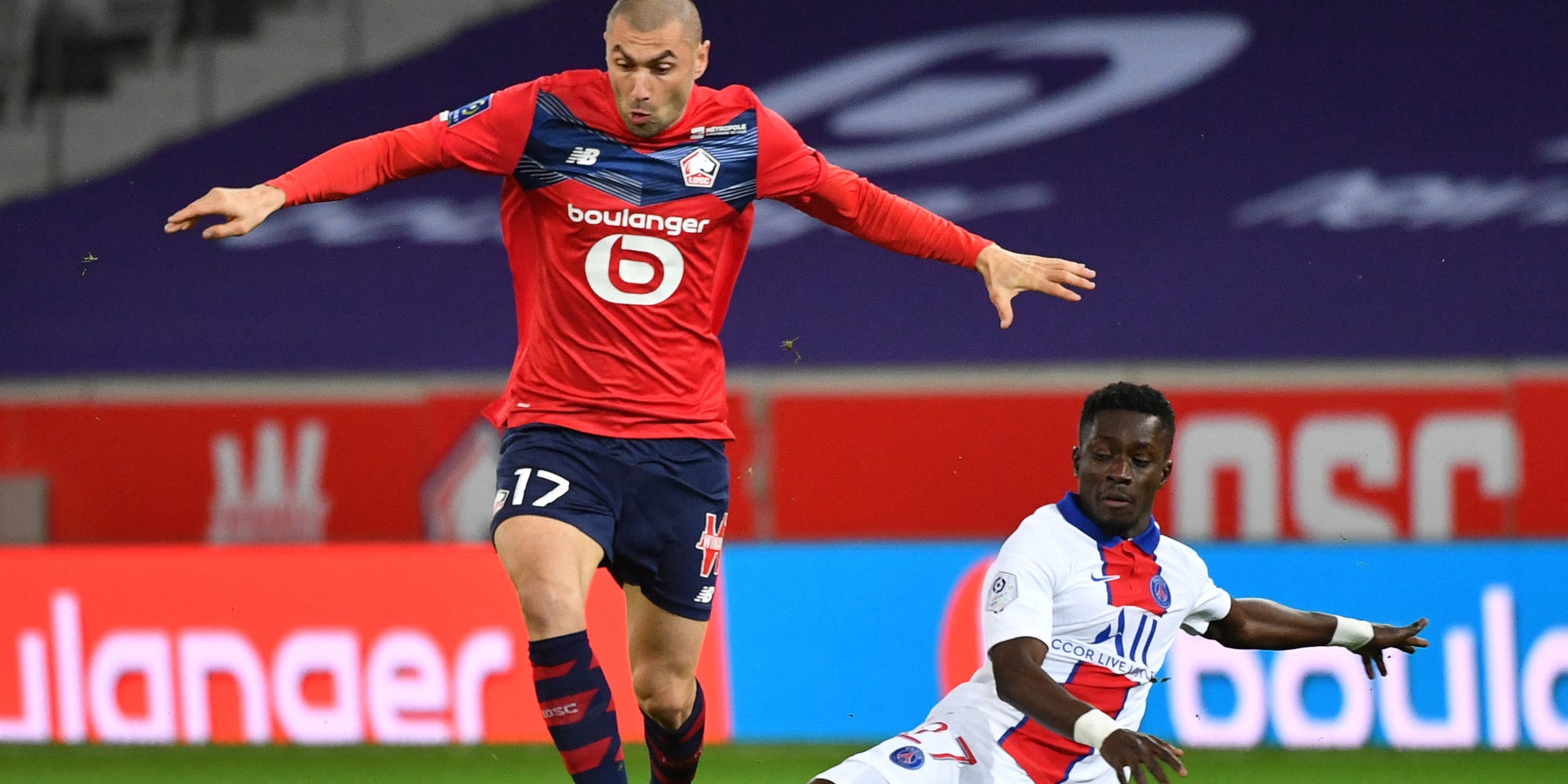 Burak Yilmaz face à Idrissa Gueye dans un match de Ligue 1 LOSC - PSG, au stade Pierre-Mauroy de Lille, le 20 décembre 2020.