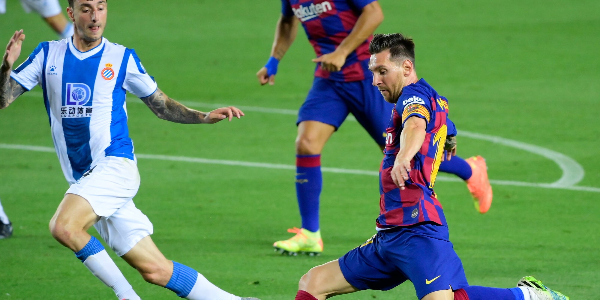 Lionel Messi face au défenseur de l'Espanyol Fernando Calero, lors d'un match de Liga au Camp Nou de Barcelone, le 8 juillet 2020.