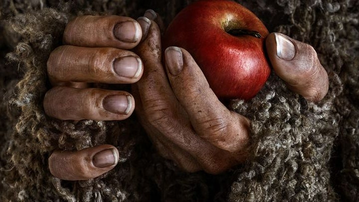 L'affiche promo qui montre les mains de l'Étranger, avec une pomme
